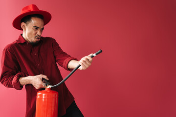 Emotional young man holding fire extinguisher