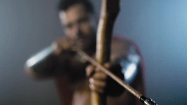 Bow and arrow in hand of roman hunter.