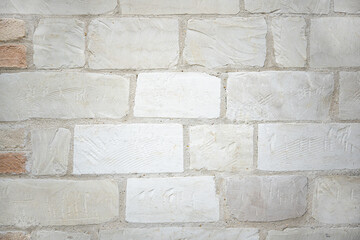 A close up of a Clunch (soft limestone) block wall with hand tooling marks.
