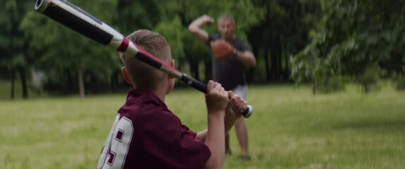 MED Father and son playing baseball in the park on a rainy day. Family time spent together. Shot with 2x Anamorphic lens - Powered by Adobe