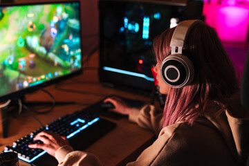 Image of caucasian focused girl playing video game on personal computer - Powered by Adobe