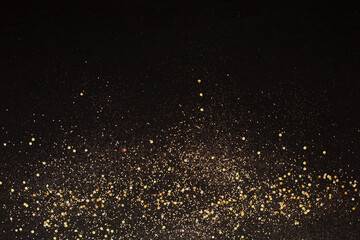 Fototapeta na wymiar Gold glitter on black background. Holiday abstract texture