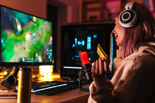 Image Of Girl Holding Credit Card And Playing Video Game On Computer