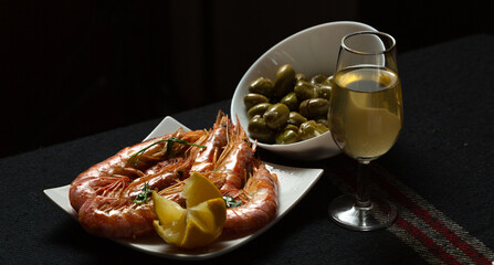 Aperitivo con gambas y aceitunas verdes con copa de vino fino 