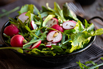 Fresh vegetable salad with radish, arugula and lettuce