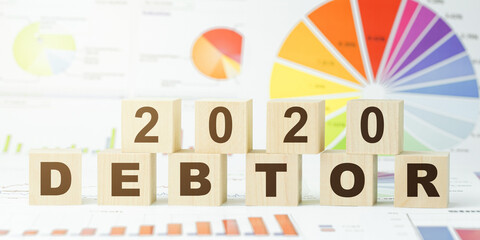 word debtor and number twentieth year with wooden cubes
