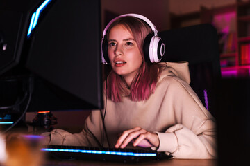 Image of unhappy focused girl playing video game on computer © Drobot Dean
