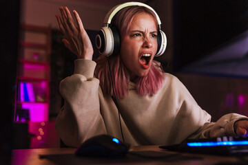 Image of displeased girl expressing irritation while playing video game