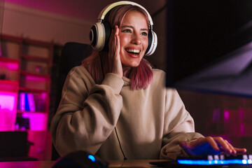 Image of joyful girl smiling and playing video game on computer © Drobot Dean