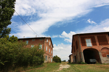 Fototapeta na wymiar Case rurali abbandonate nella campagna in un paesaggio di pianura 