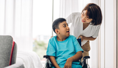 Portrait of enjoy happy love family asian mother playing and carer helping look at disabled son child sitting in wheelchair moments good time at home.disability care concept