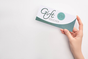 Top view of woman holding gift voucher with 50 dollars sign on white background