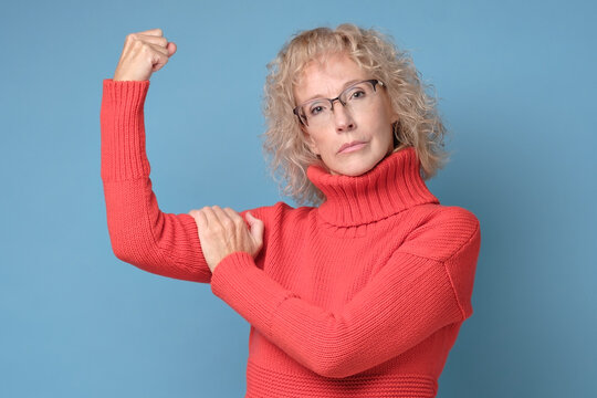 Strong Powerful Mother Raises Arms And Shows Biceps. Woman Power Concept.