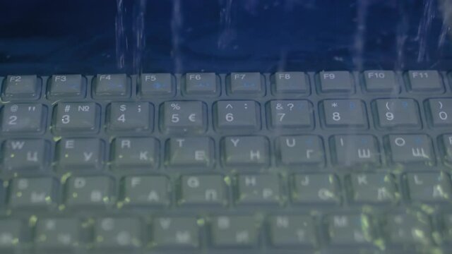 Protective, resistant, safety, technology concept. Keyboard of waterproof rugged laptop computer for military, outdoor and industrial use during shaking, water resistance test - heavy rain - close up