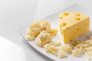 piece of Cheese and Cheddar Cheese grated on old vintage Cooking wooden table. Cheese background Texture and Copy space