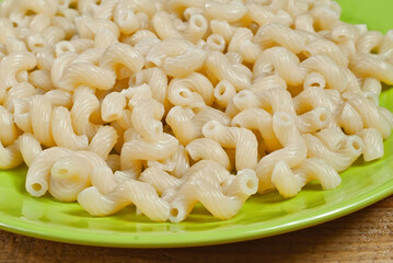 Vermicelli in a green plate on a wooden table. Food close up on an old shabby blackboard.