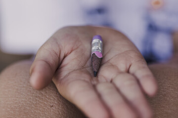 Short pencil on hand of an Asian little boy with poverty
