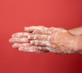 two male hands in a white soapy foam, body hygiene