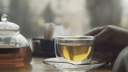 Teapot and cu with green tea on a table in cafe