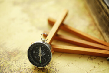 Travel and adventure search concept. Vintage aged map with a shabby book and compass. Shabby book and compass on the table.