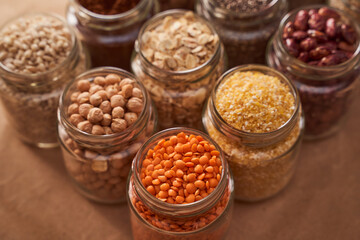 Super food grits in glass jars. Top view. lentils, chickpeas, corn, oats, beans, chia