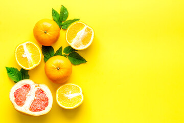 Citrus fruits on yellow background top view