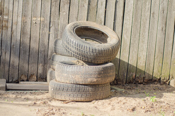 Old dirty tires lie next to wooden boards