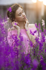 Beautiful young woman outdoors on flower field
