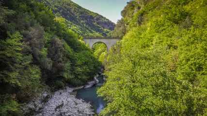 Fototapeta na wymiar Bridge Lavelle, Benevento, Italy The erosion of the water has created a real natural masterpiece surrounded by beautiful trees.