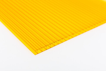 Polycarbonate plastic sheets panels images. PC hollow sheet for translucent roofing close up. Single yellow color on white background