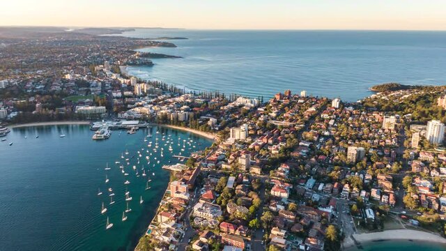 Sunset aerial drone hyperlapse of a Manly ferry departing from Manly Wharf pier, going to Sydney CBD - a 20 minute ride from Manly. Manly is a beach-side suburb of Sydney, Australia.	