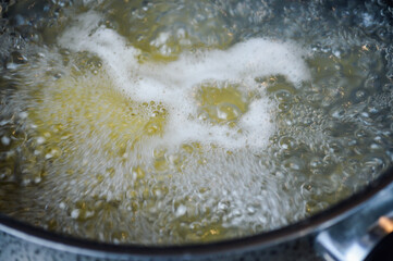 Italian pasta cooking in boiling salted water. Cooking pasta at home, close up.