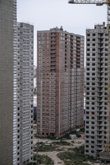 Large construction site on a background of blue sky. Brick, panel apartment building. Industrial theme for design