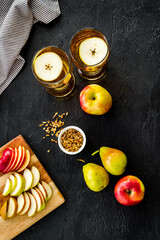 Fruit drinks with apple and pear on black background from above
