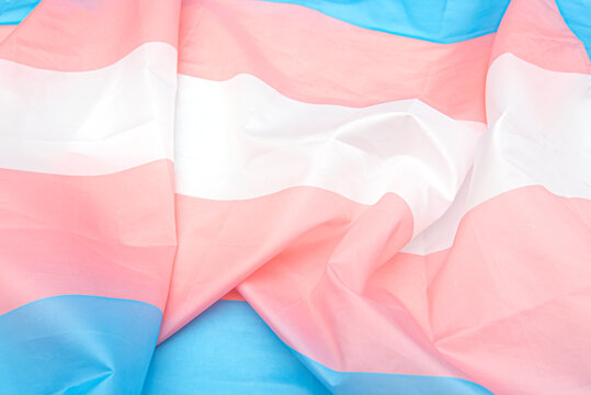 Transgender fabric flag with white, pink, blue strips. Close-up transgender pride flag as background or texture