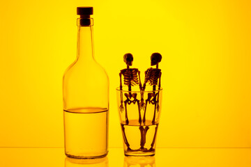a bottle of alcohol and a glass with skeletons as harbingers of death. harm from drinking alcohol