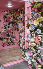 Flower design of a photo zone on the street with a telephone box. Colorful plants for the design of your home. Stock photo background