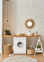 Washing machine in the laundry room, wooden table and shelf style, sink lamp mirror and wicker...