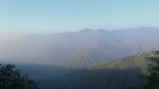 Garhwal Himalayan range at the background during morning hours with golden and blue colors in Mussoorie, slow motion panoramic shot.