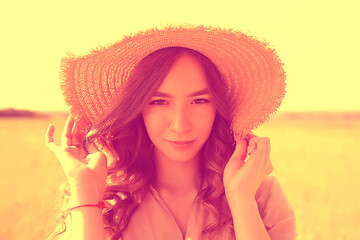 summer portrait of a girl in a straw hat in a field / landscape in a yellow wheat field, rustic romance of Provence