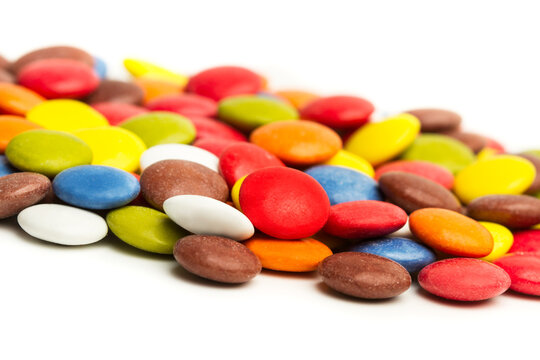 Grageas de chocolate de colores sobre un fondo blanco aislado. Vista de frente y de cerca. Copy space. Macro