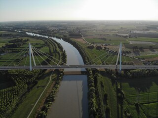 Aerial view of a modern bridge over a river in northern Italy.