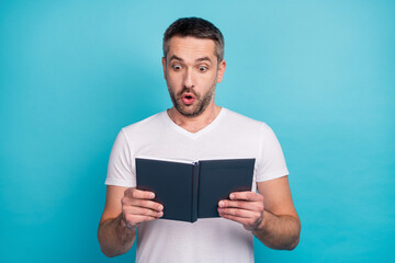 Close-up portrait of his he nice attractive cheerful cheery amazed bearded guy reading interesting book isolated over bright vivid shine vibrant blue color background