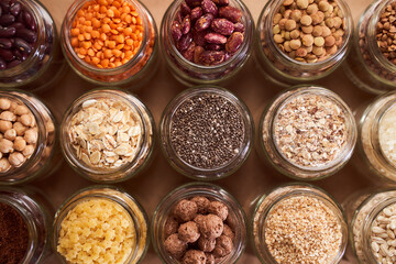 Super food grits in glass jars. Top view. lentils, chickpeas, corn, oats, beans, chia