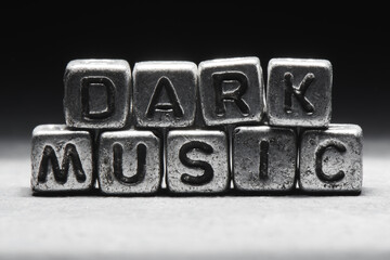 The concept of dark music. The inscription on metal 3D cubes isolated on a black background, grunge style