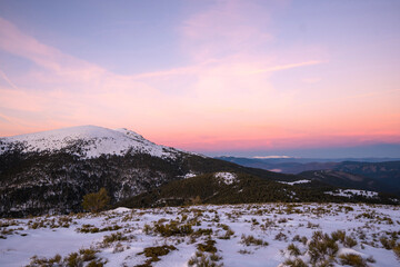 Sunset in mountains. Winter scenery. Beautiful pink and white sky, windy weather. Pink, purple and blue mild pastel colors. Navacerrada. Madrid