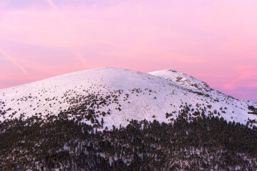 Sunset in mountains. Winter scenery. Beautiful pink and white sky, windy weather. Pink, purple and blue mild pastel colors. Navacerrada. Madrid