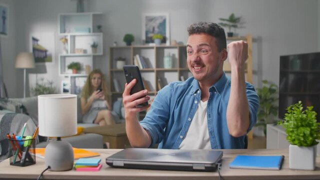 Couple winners hold smartphone feel amazed overjoyed with mobile online bet bid app game win
