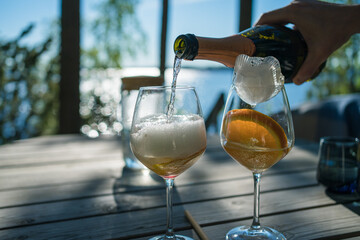 making a summer drink with sparkling wine in sunset outside