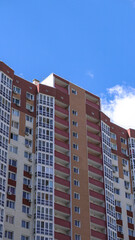 Large construction site on a background of blue sky. Brick, panel apartment building. Industrial theme for design